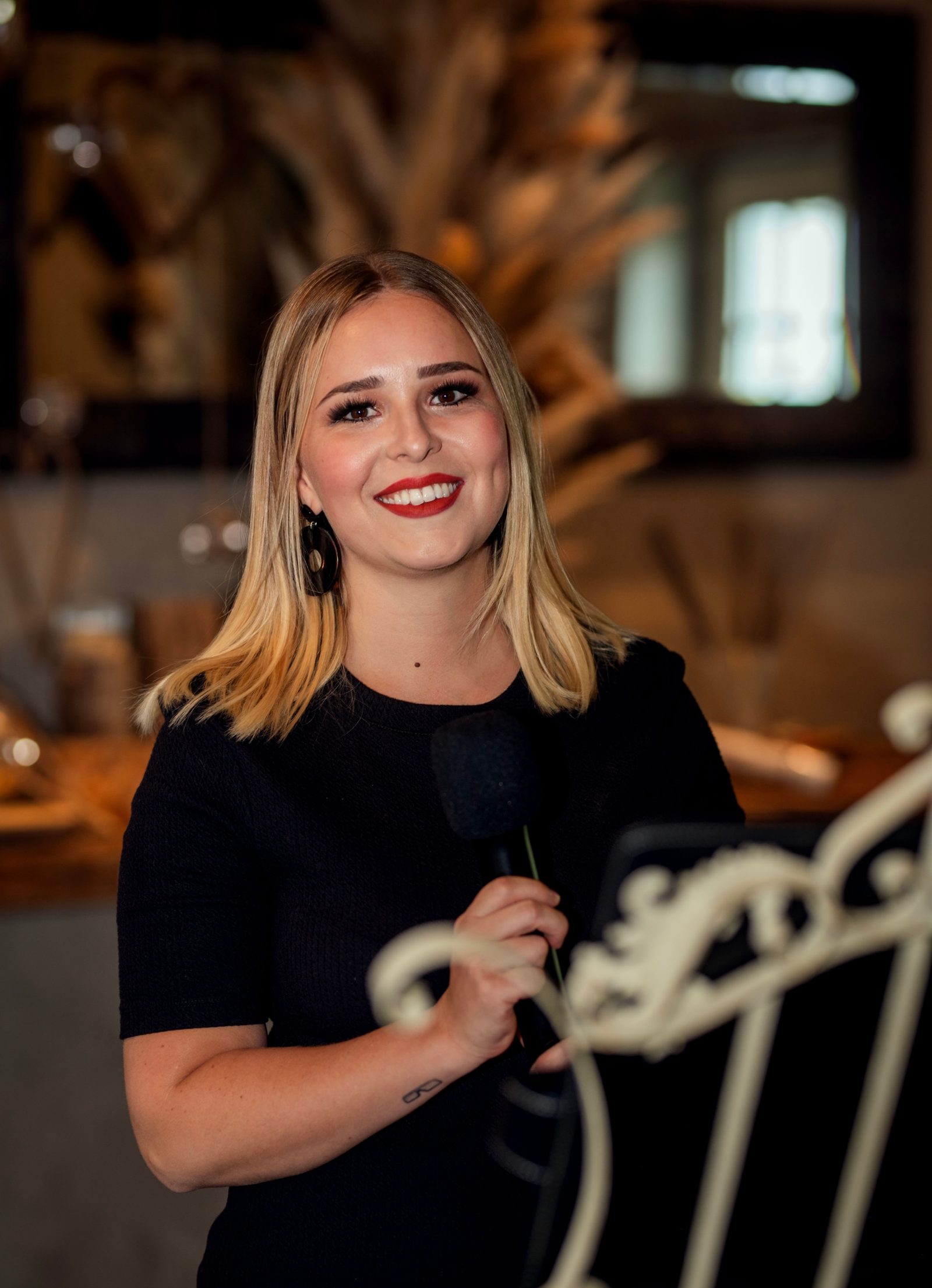 Selina am Mikrofon bei einer Trauung, warme Lichterketten